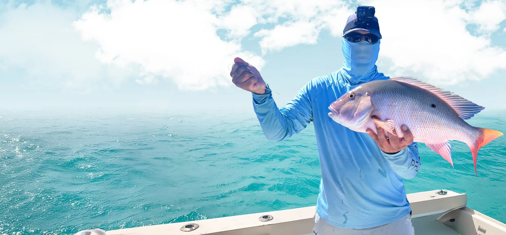 Angler in a sun shirt holding up a fish against a bright Keys sky