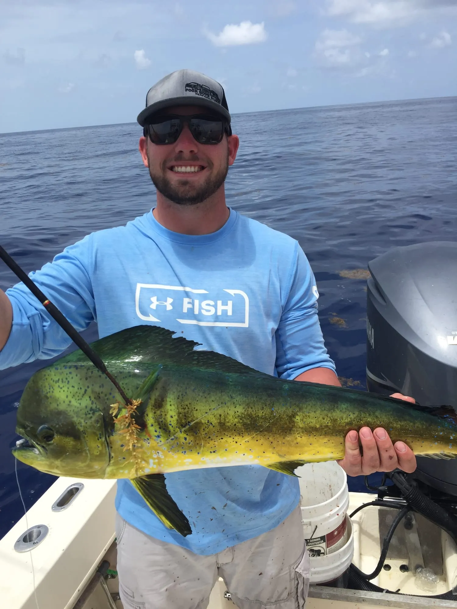Angler holding a mahi-mahi he caught aboard Satisfaction