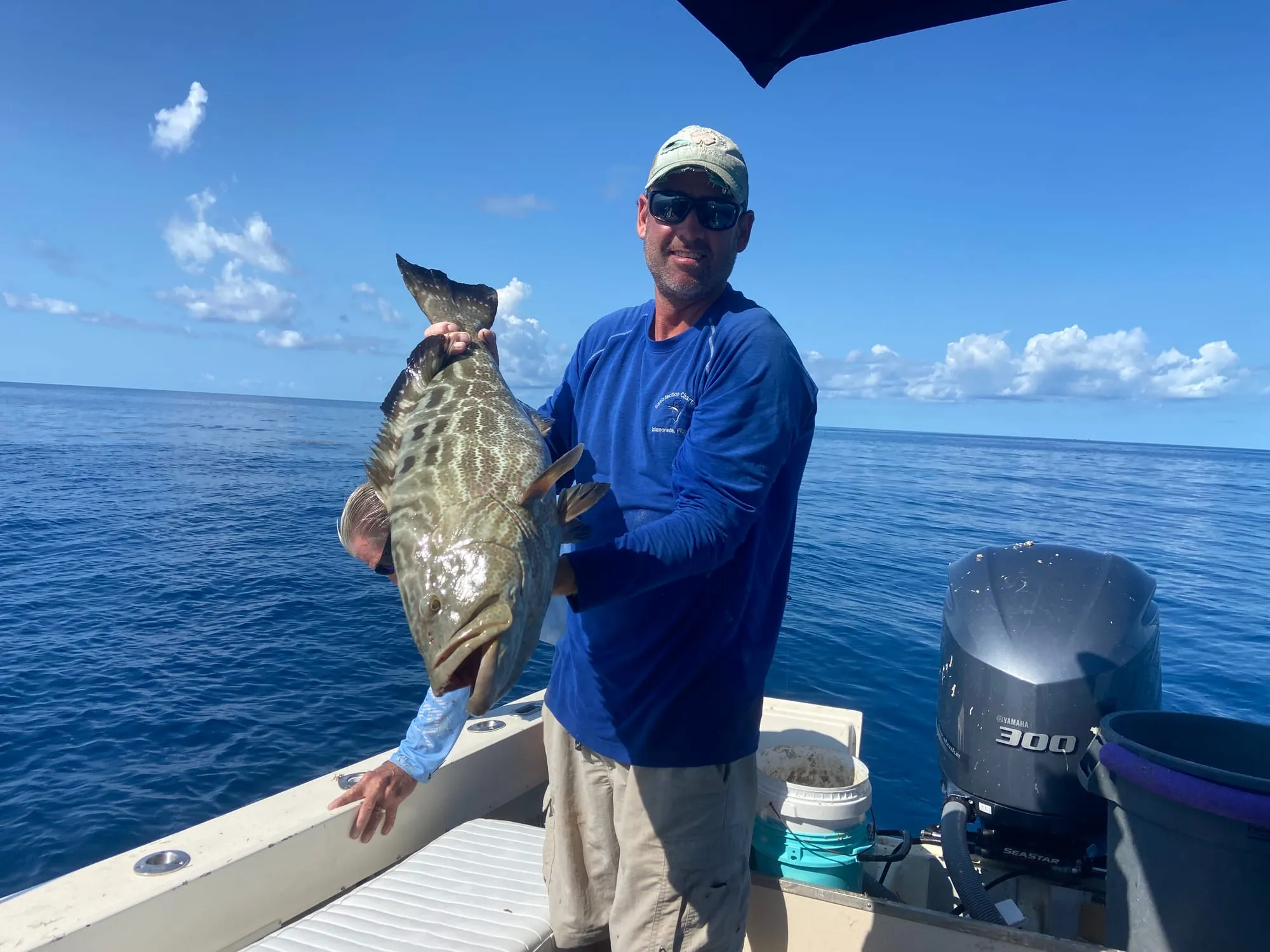 Angler holding a grouper on a sunny day offshore