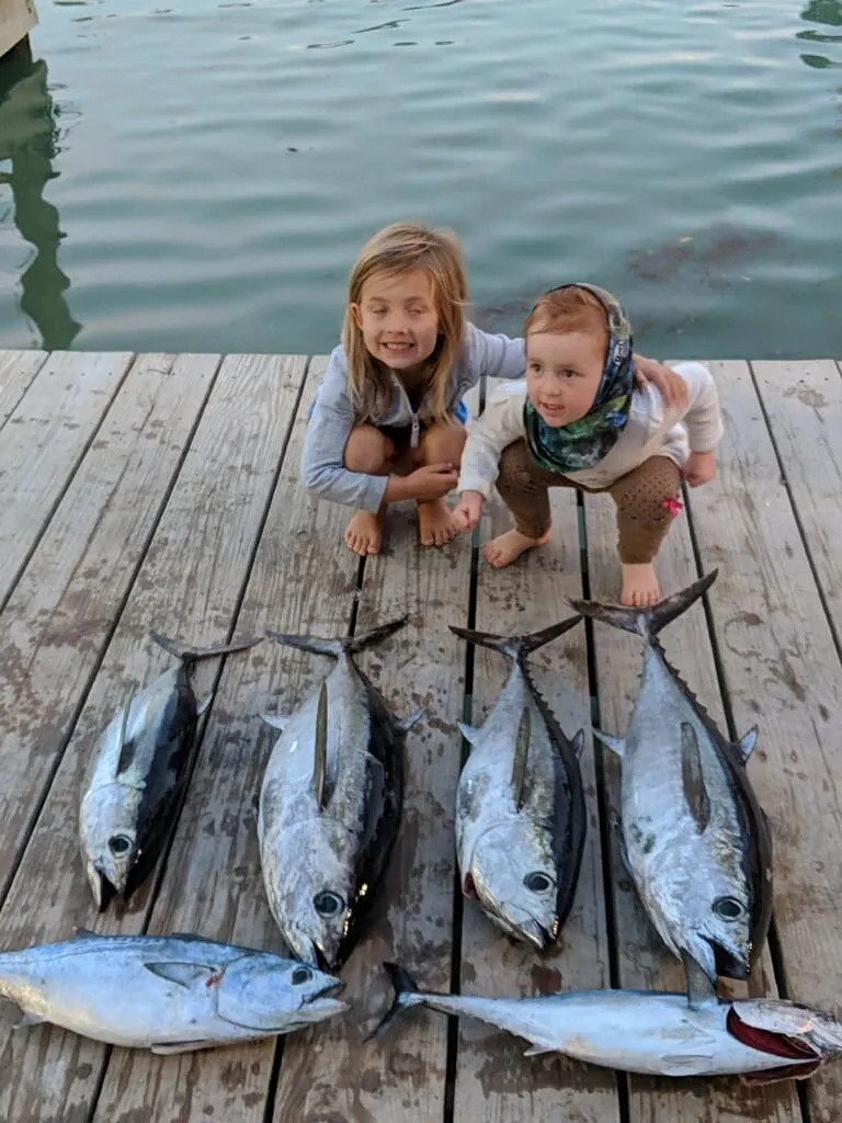 Two kids on the dock with blackfin tuna they caught