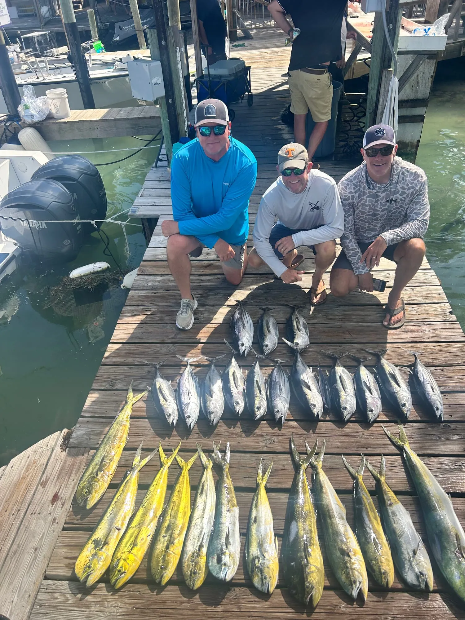 Anglers on the dock with a row of mahi and tuna