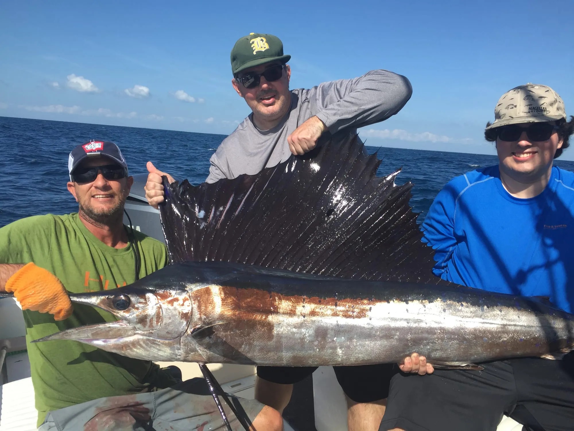 Three anglers holding a sailfish