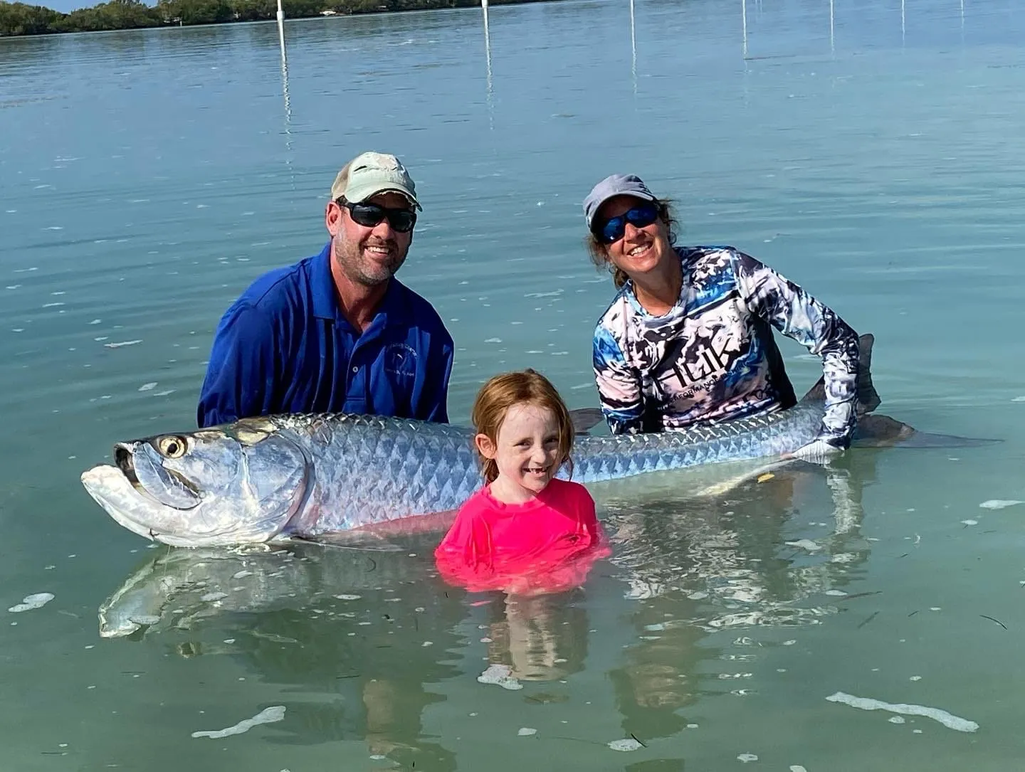 Family in the shallows releasing a large tarpon
